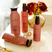 PUREology hair care products on a white surface with flowers in the background
