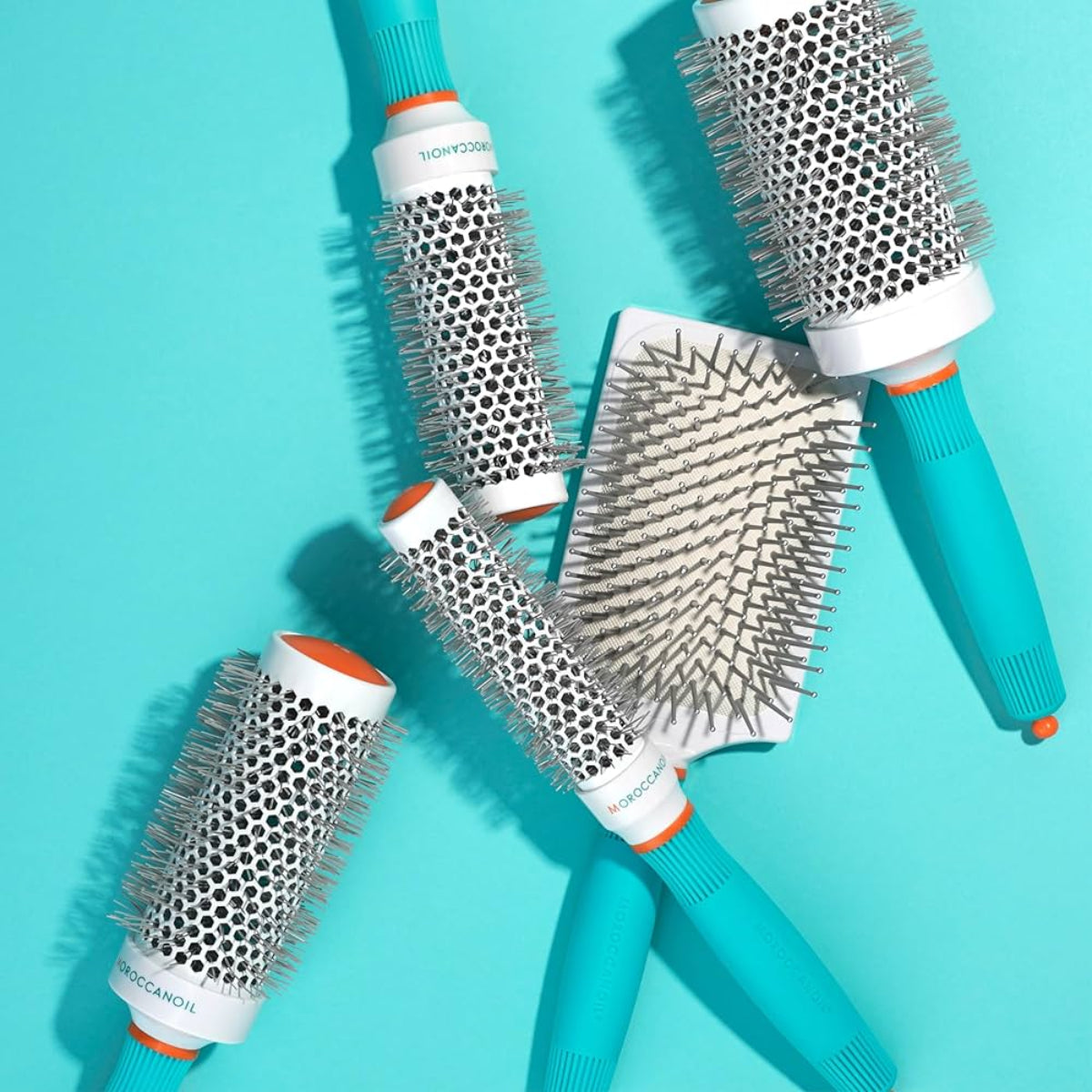 Set of hairbrushes with different bristle patterns on a turquoise background