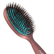 Hairbrush with brown handle and black bristles on a white background