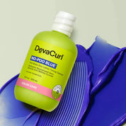 Devacurl No-Poo Blue bottle on a purple background