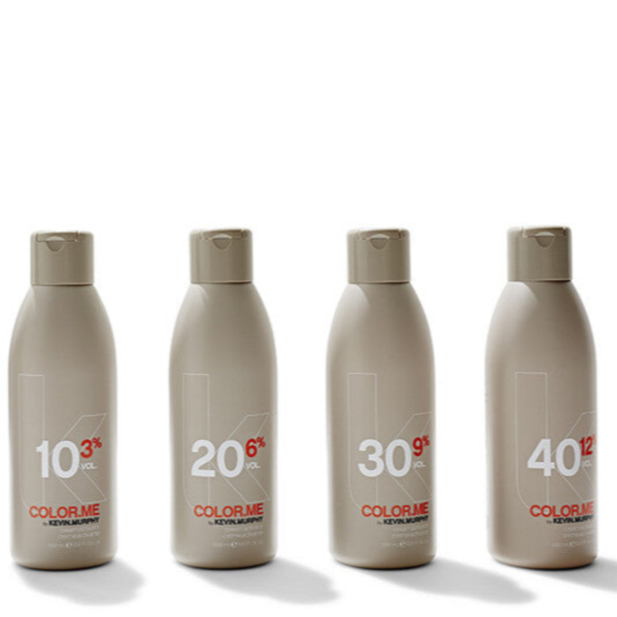 Four bottles of Color Me hair color with different percentages on a white background