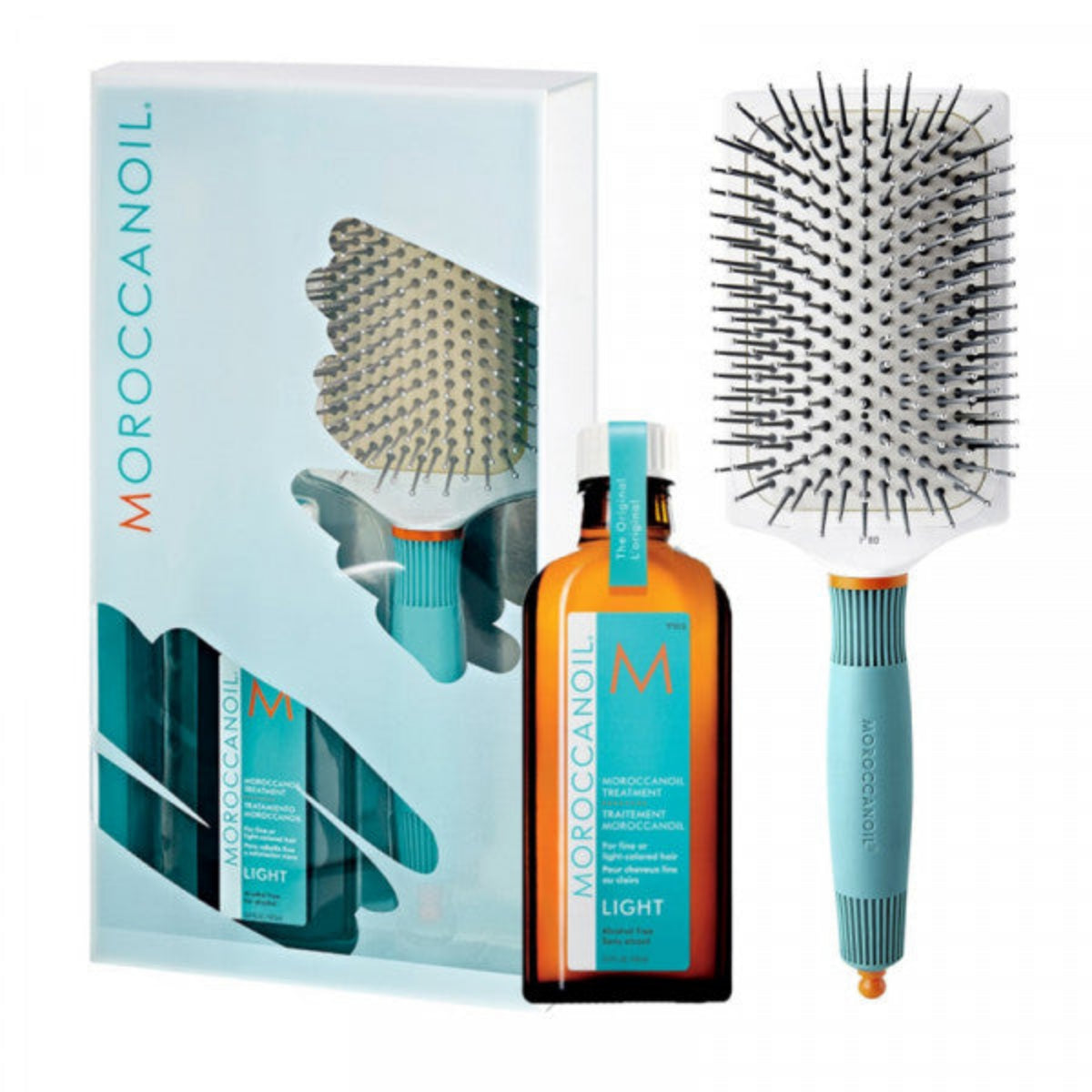 Moroccanoil hair care set with bottle, brush, and packaging on a white background